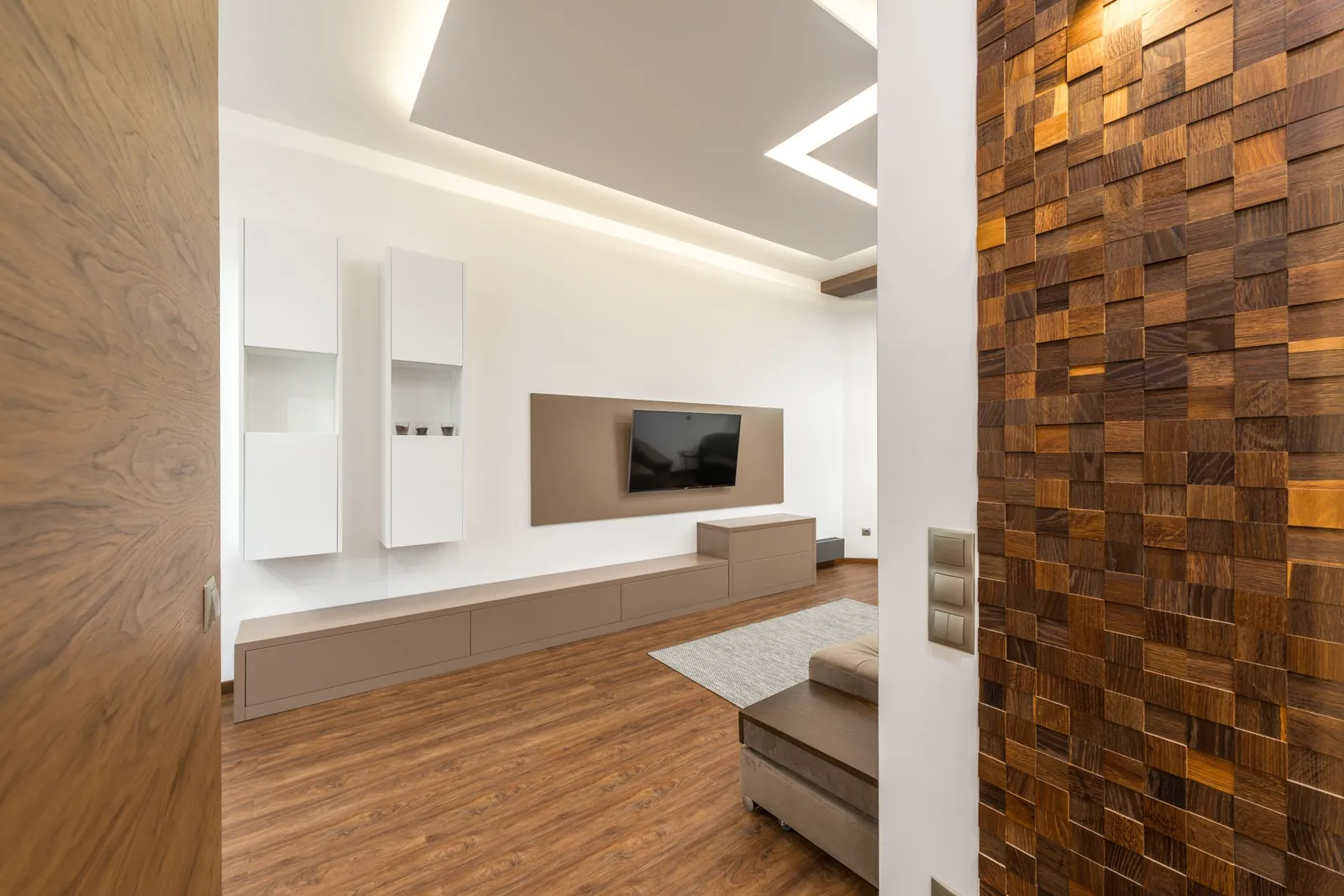 A finished modern living room with a wood accent wall