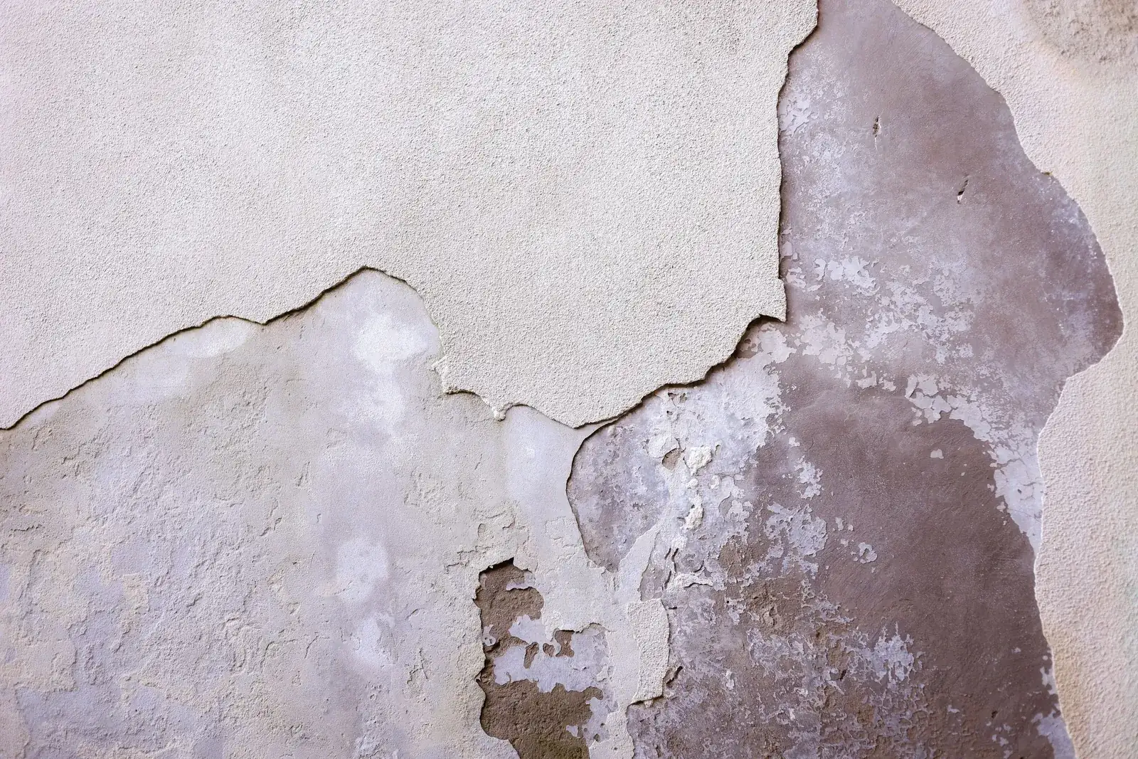 A cracked and peeling plaster wall in close-up