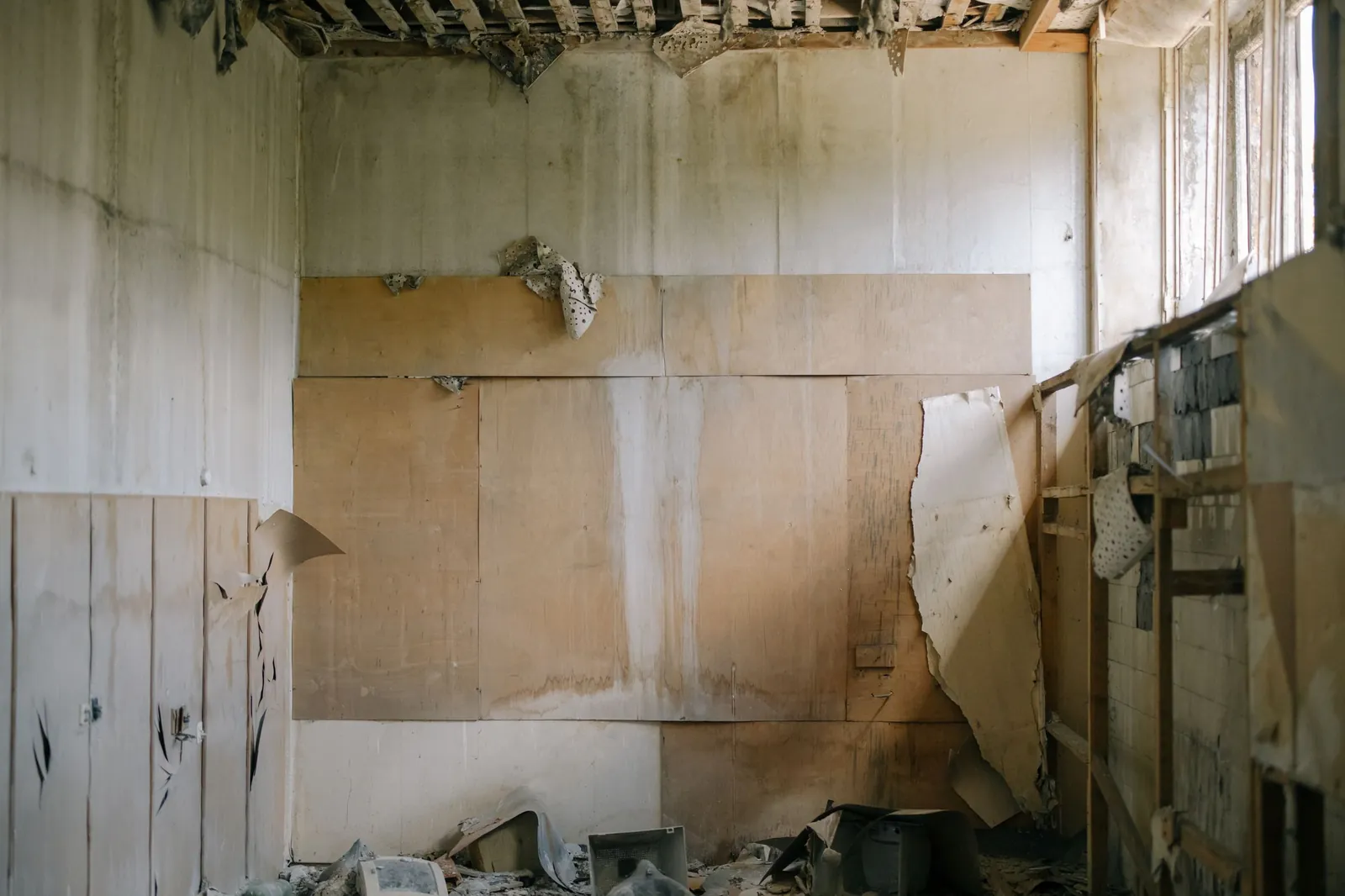 A wall with water damage and peeling surface material