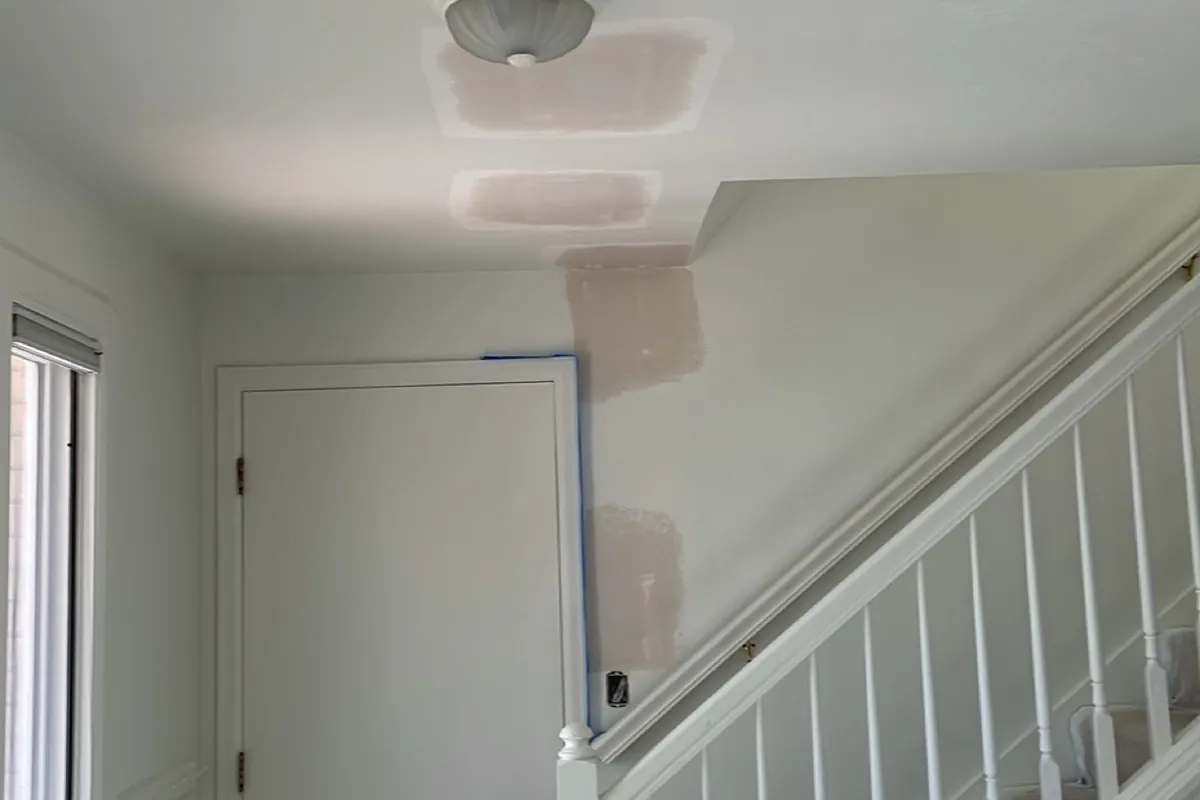 A finished entry wall and stairwell on an Aurora job, patched and sanded flat.